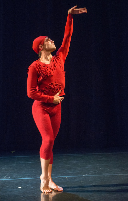 Sila stands with one foot beveled his left hand extends above his head. His hand looks like it is fluttering